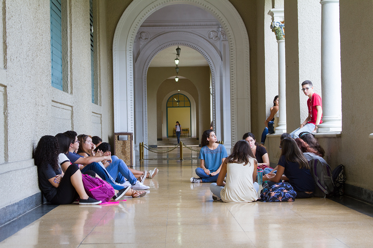 Estudiantes sentados conversando en pasillo de la Torre de la Universidad de Puerto Rico, Recinto de Río Piedras